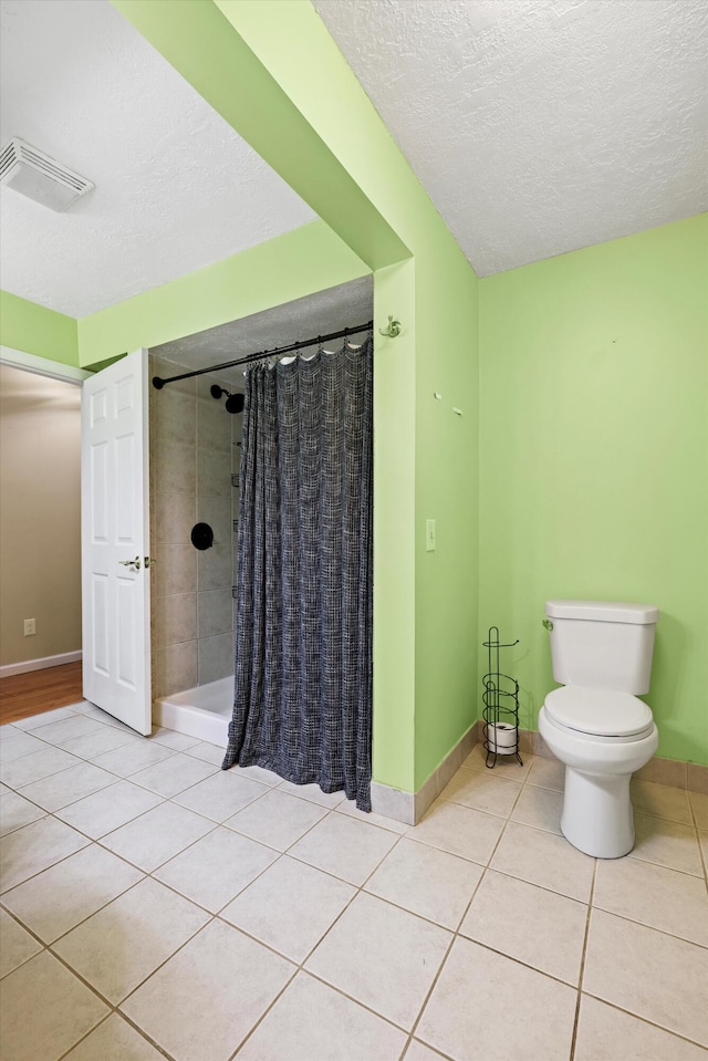 bathroom with tile patterned floors, visible vents, a shower with shower curtain, and a textured ceiling