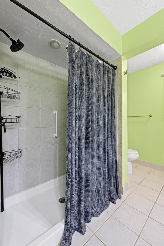 full bath featuring toilet, a textured ceiling, a stall shower, and tile patterned flooring