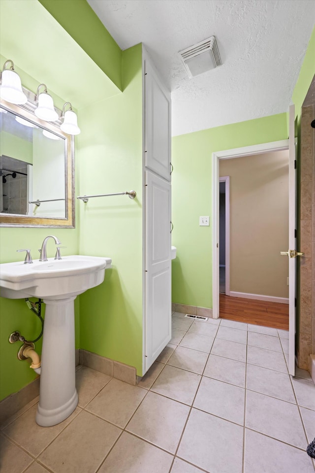 bathroom with tile patterned floors, visible vents, and baseboards