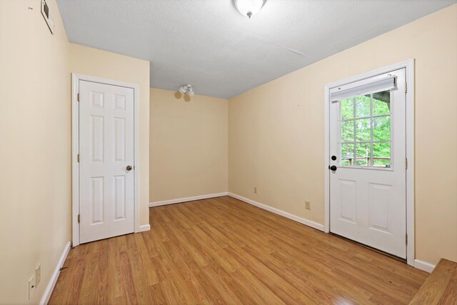 empty room with light wood finished floors and baseboards