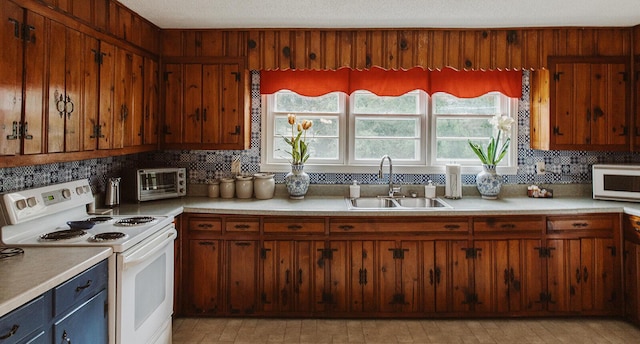 kitchen with backsplash, a sink, light countertops, a toaster, and white appliances
