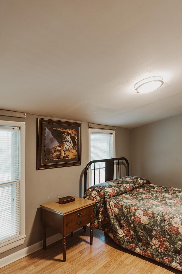 bedroom with light wood-style floors and baseboards