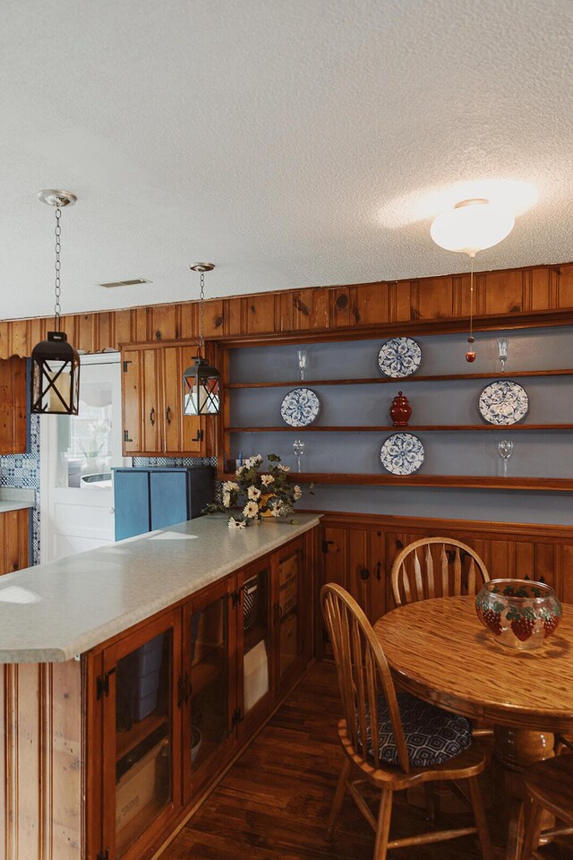 kitchen featuring open shelves, decorative light fixtures, a textured ceiling, and dark wood-type flooring