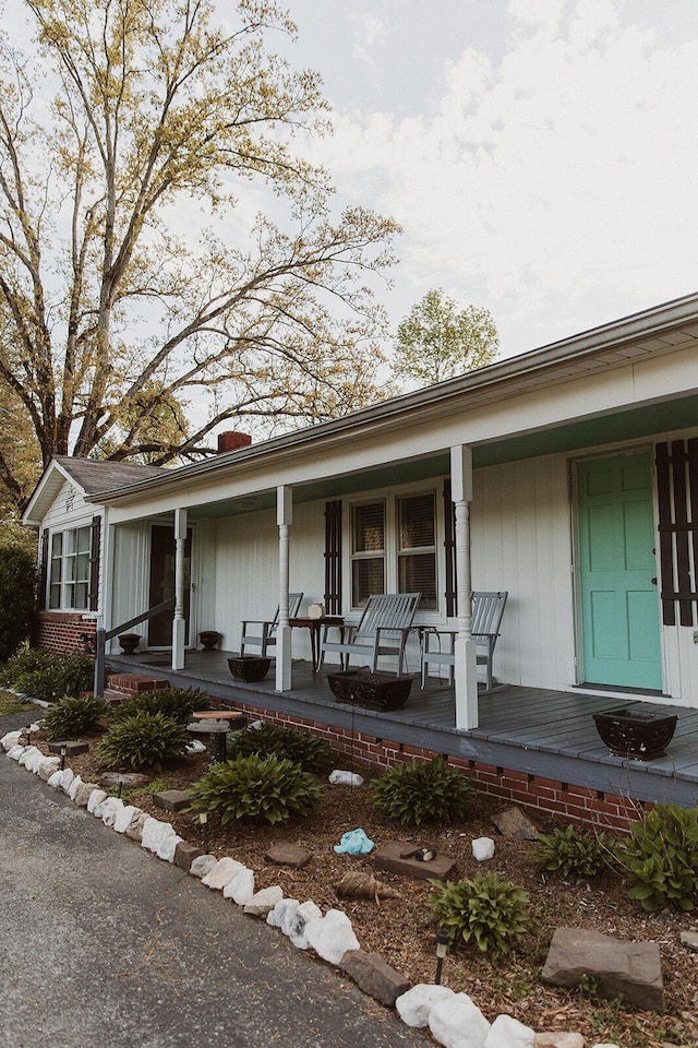 view of front of house with covered porch and a chimney