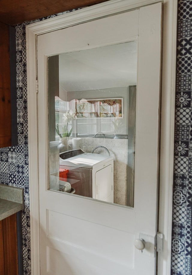 interior details with washer / clothes dryer and wallpapered walls