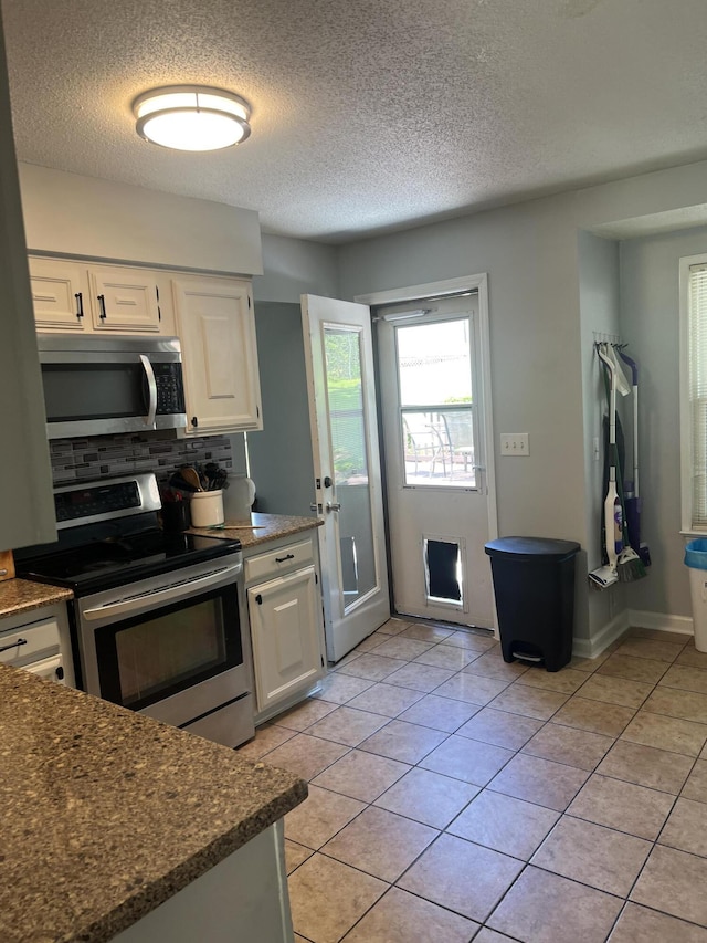 2288 Edgmon Forest Ln, Chattanooga, TN 37421 - kitchen featuring stainless steel appliances, white cabinetry, tasteful backsplash, light tile patterned flooring, and a textured ceiling