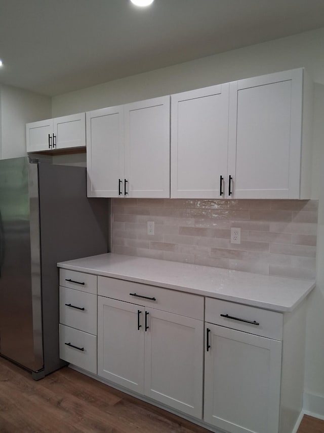 1302 Peter Pan Rd, Lookout Mountain, GA 30750 - kitchen with dark wood finished floors, white cabinets, tasteful backsplash, light countertops, and freestanding refrigerator