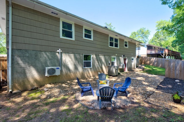 back of property featuring fence, ac unit, an outdoor fire pit, cooling unit, and a patio