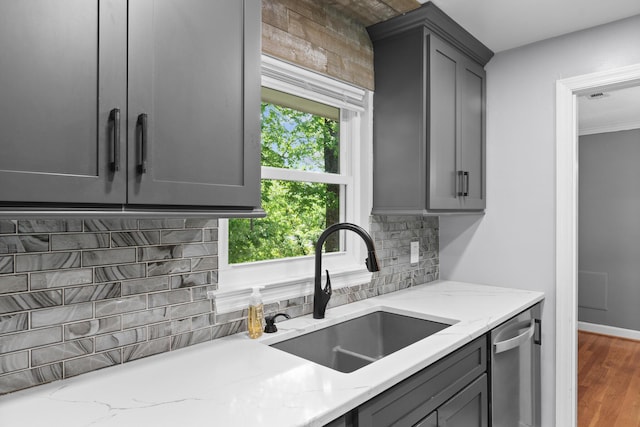 kitchen featuring decorative backsplash, gray cabinetry, plenty of natural light, and a sink