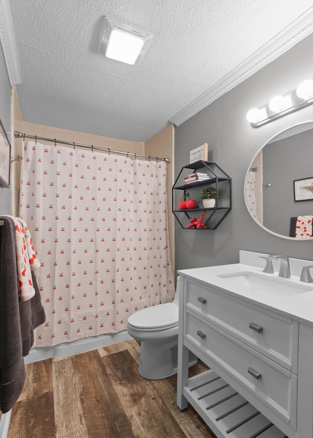 bathroom with vanity, wood finished floors, toilet, a textured ceiling, and a shower with curtain