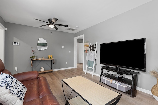living area with visible vents, baseboards, wood finished floors, and ceiling fan