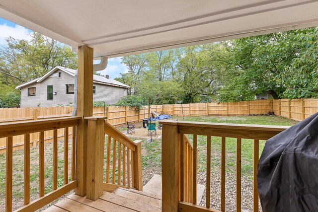 wooden deck featuring a lawn and a fenced backyard