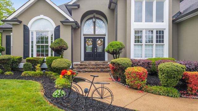 doorway to property featuring stucco siding and french doors