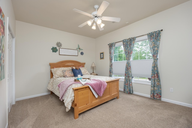 bedroom with baseboards, a ceiling fan, and light carpet