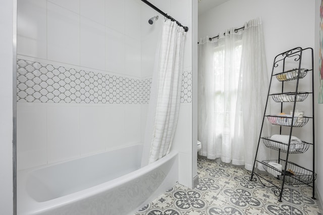 full bath with shower / bath combo with shower curtain, toilet, and tile patterned flooring