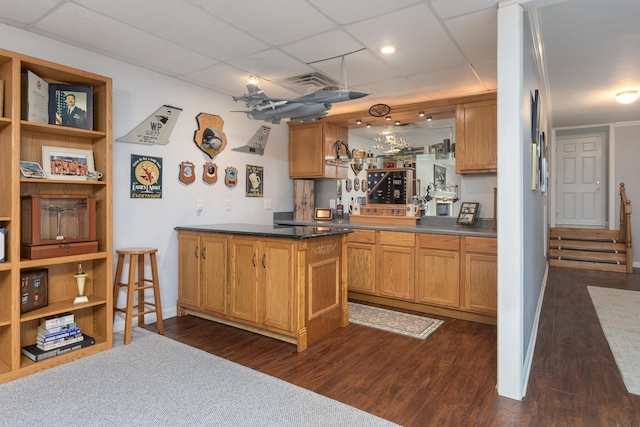 bar featuring indoor wet bar, visible vents, a drop ceiling, and dark wood-type flooring