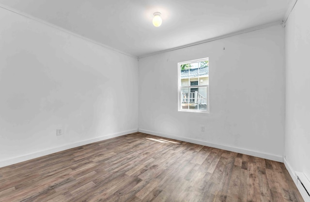unfurnished room featuring baseboards, ornamental molding, a baseboard heating unit, and wood finished floors