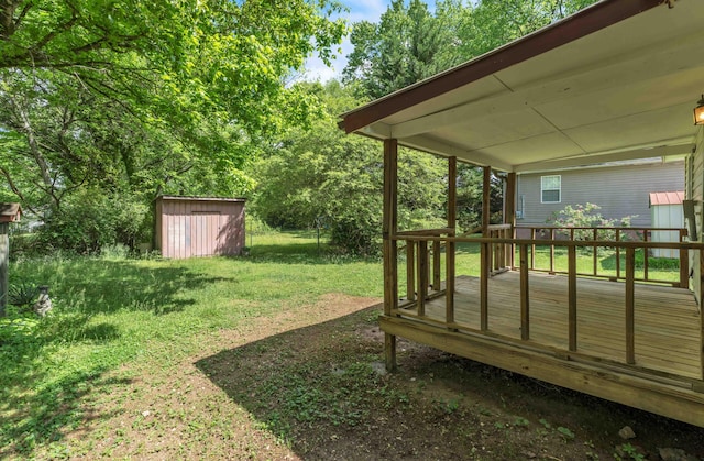 view of yard featuring an outdoor structure, a shed, and a wooden deck