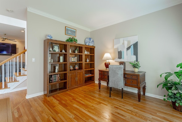 office space featuring crown molding, a ceiling fan, baseboards, and wood finished floors