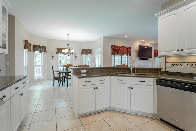kitchen with an inviting chandelier, a sink, dishwasher, light tile patterned floors, and glass insert cabinets