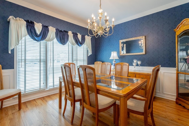 dining space with a chandelier, plenty of natural light, wood finished floors, and a wainscoted wall