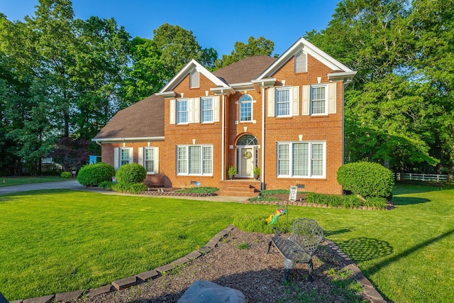 colonial-style house with brick siding, a front lawn, and roof with shingles