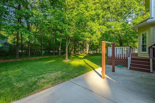 view of yard featuring a patio area, a wooden deck, and fence