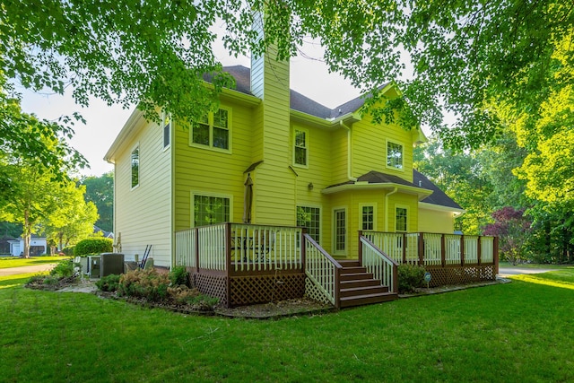 back of house featuring a lawn, a chimney, cooling unit, and a deck