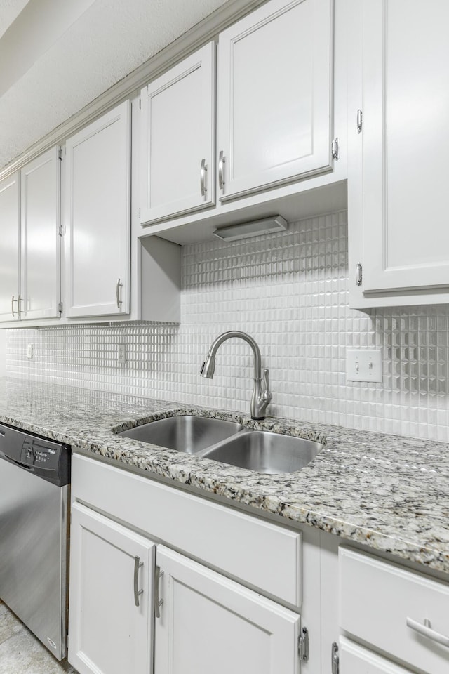 kitchen with decorative backsplash, stainless steel dishwasher, and a sink