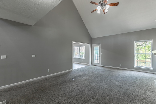 carpeted empty room featuring ceiling fan, high vaulted ceiling, and baseboards