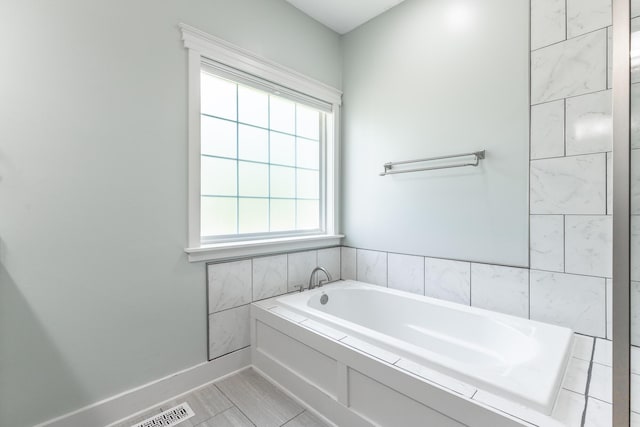 bathroom featuring a bath, tile patterned flooring, and visible vents