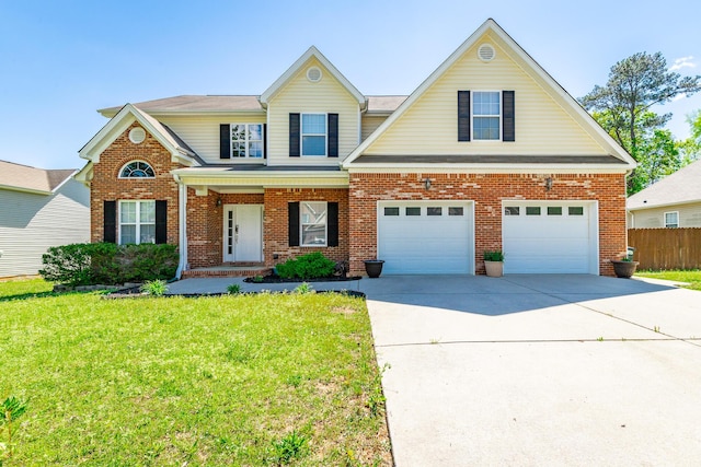traditional home with concrete driveway, a front yard, an attached garage, fence, and brick siding