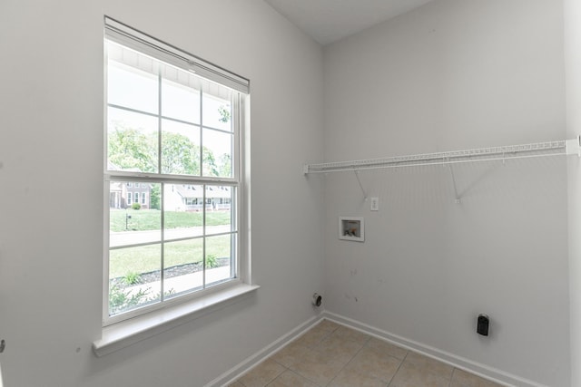 laundry area with baseboards, hookup for a washing machine, light tile patterned floors, and laundry area