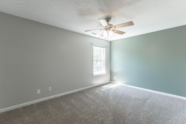 spare room with baseboards, ceiling fan, a textured ceiling, and carpet