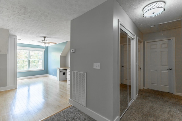 bonus room featuring attic access, ceiling fan, visible vents, baseboards, and a textured ceiling