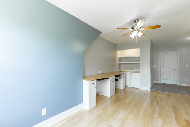 unfurnished office featuring baseboards, light wood-type flooring, and a ceiling fan