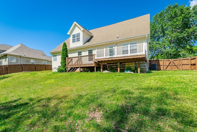 back of property with a yard, a wooden deck, and a fenced backyard