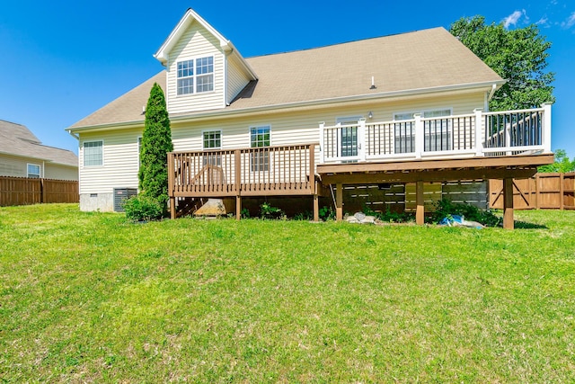 rear view of property featuring a deck, fence, and a yard