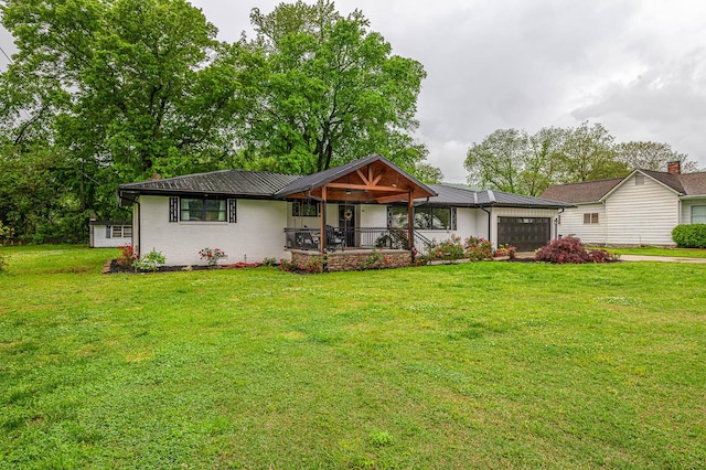 ranch-style house featuring metal roof, a front lawn, a garage, and covered porch