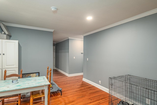 dining space with crown molding, light wood-style flooring, and baseboards