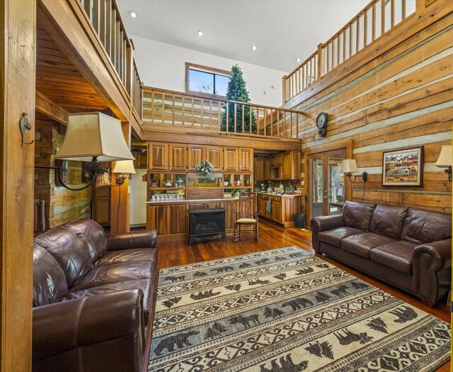 1011 Buffalo Rd, Jefferson City, TN 37760 - living area featuring wooden walls, a wood stove, a high ceiling, and dark wood finished floors