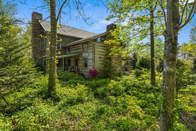 1011 Buffalo Rd, Jefferson City, TN 37760 - view of side of home featuring a chimney, a standing seam roof, a porch, and metal roof
