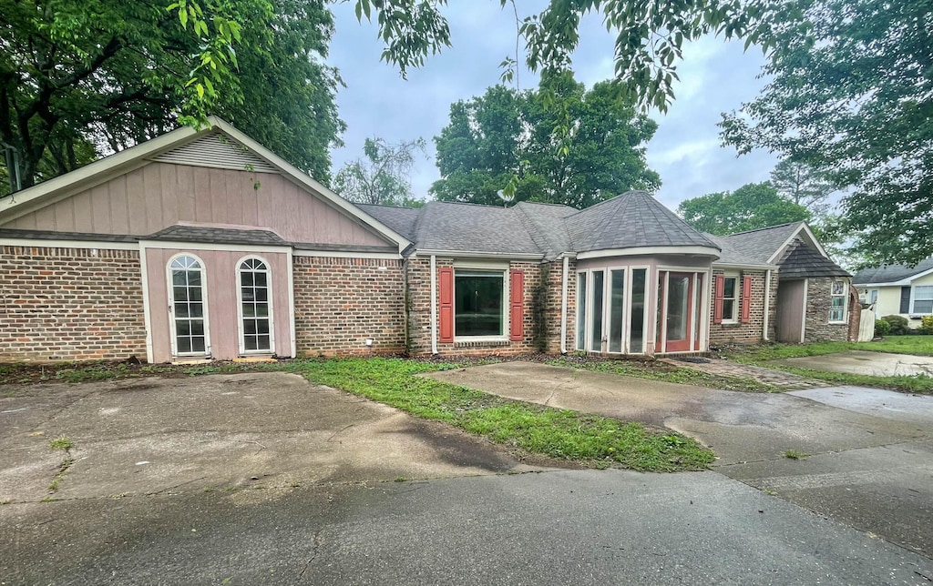 view of front of house with a shingled roof and brick siding