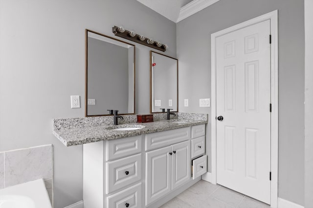 full bathroom with double vanity, a sink, and baseboards