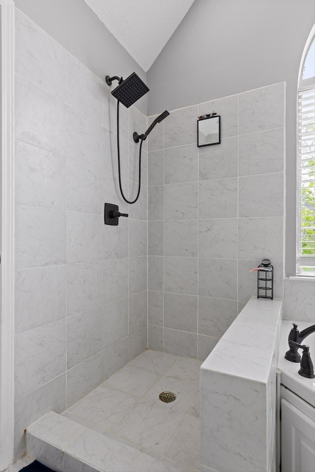 full bath featuring vaulted ceiling and tiled shower