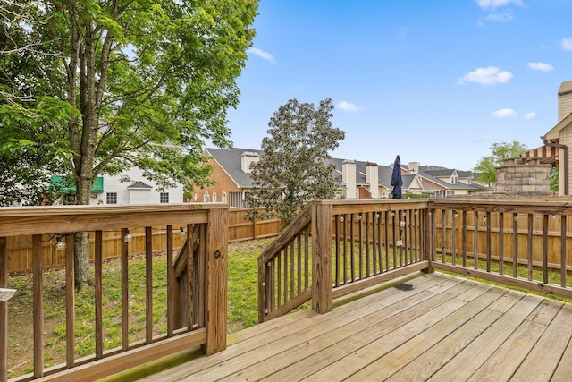 wooden terrace with a residential view and a fenced backyard