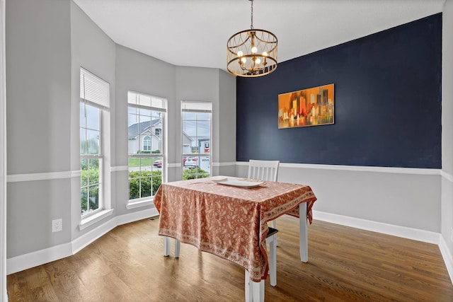 dining room with baseboards, an inviting chandelier, plenty of natural light, and wood finished floors