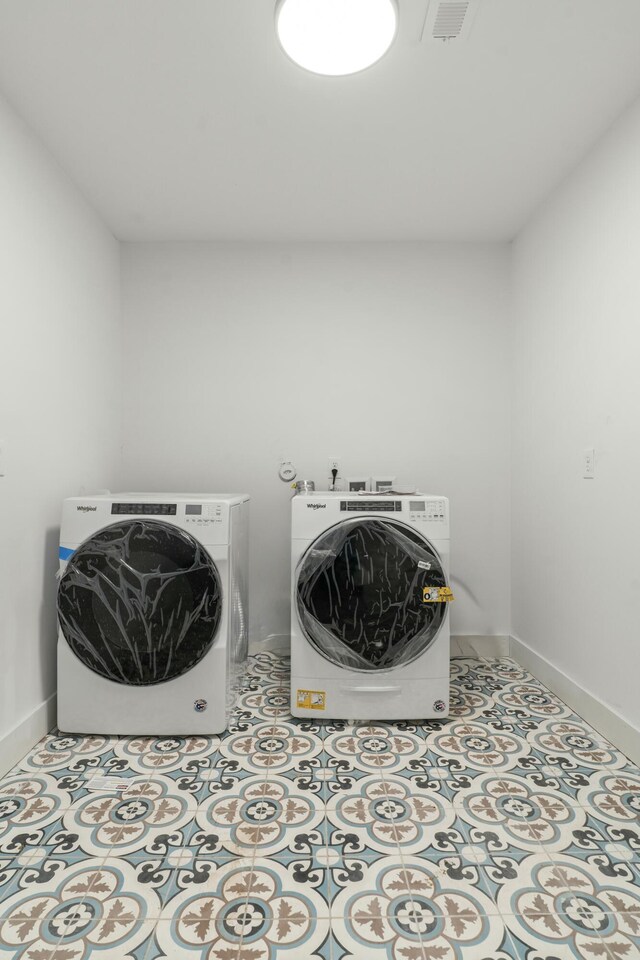 laundry room featuring baseboards, visible vents, separate washer and dryer, and laundry area