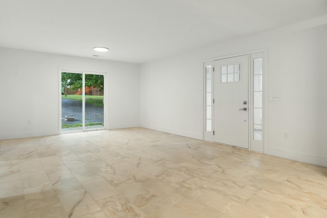 foyer entrance featuring marble finish floor and baseboards