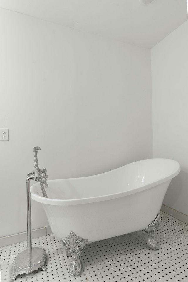 full bath with baseboards, a freestanding tub, and tile patterned floors